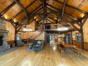 Great Room with distressed Wood Flooring Wood Beams and Wood Wall Panels