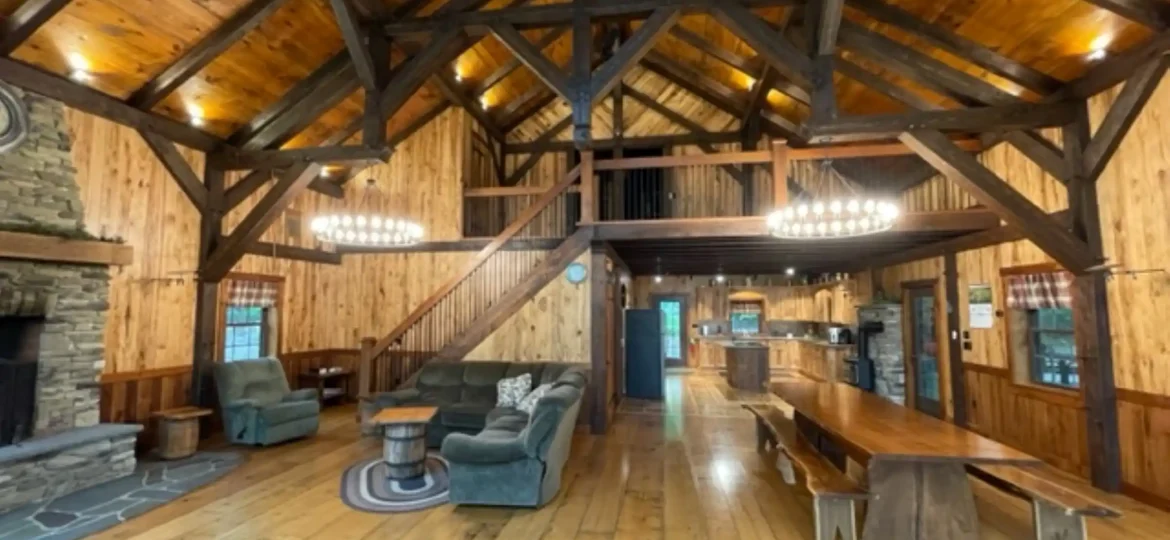 Great Room with distressed Wood Flooring, Wood Beams and Wood Wall Panels